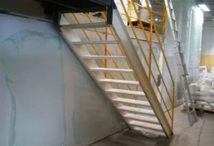Construção de Sala Limpa, fechamento lateral com divisórias para sala limpa em uma escada de acesso ao piso superior numa linha de produção.