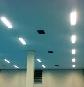 A terceira imagem traz as luminárias de salas limpas instaladas e acesas, mostrando o forro iluminado e finalizado.